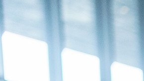 Three-quarter front shot with blurred background of a mixed-race little kid taking the lead and walking in front of their multicultural family to be the first one who finds the exit of the airport.