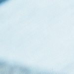 High angle view looking down at a cute multiracial toddler girl sitting in her father's lap and feeding herself while having dinner with her multi-generation family during a weekend gathering.