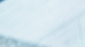 High angle view looking down at a cute multiracial toddler girl sitting in her father's lap and feeding herself while having dinner with her multi-generation family during a weekend gathering.