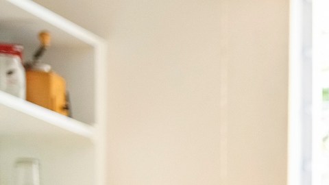 Children sitting at dining table while their mother helping them with homework at home